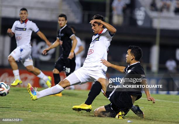 Libertad's player Nestor Camacho vies for the ball with David Mendoza of Nacional during the Paraguayan Clausura tournament football final match on...