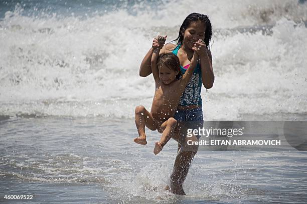 Peruvian natives enjoy the beach during a gathering to call awareness on climate change at Agua Dulce beach in Lima's Chorrilllos district on...