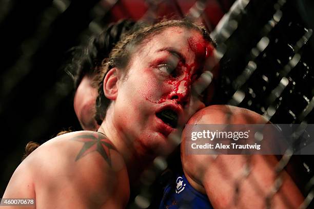 Raquel Pennington and Ashlee Evans-Smith grapple against the cage in their fight during the UFC 181 event at the Mandalay Bay Events Center on...