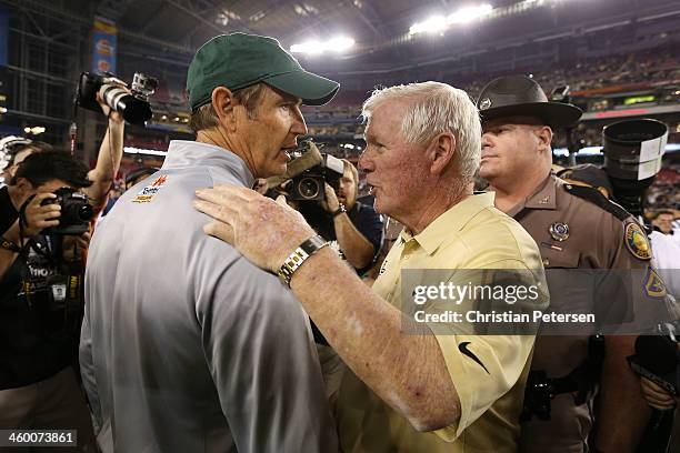 Head coach George O'Leary of the UCF Knights shakes hands with head coach Art Briles of the Baylor Bears after the Knights defeated the Bears 52 to...