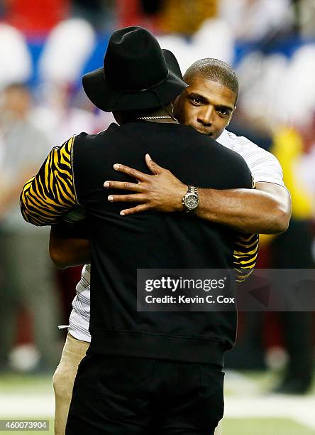 Players Michael Sam and Sean Weatherspoon of the Atlanta Falcons attend the SEC Championship game between the Alabama Crimson Tide and the Missouri...