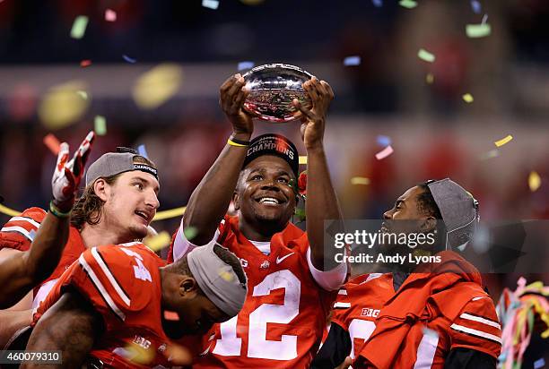 Quarterback Cardale Jones of the Ohio State Buckeyes lifts the Big Ten trophy after his team defeated the Wisconsin Badgers 59-0 in the Big Ten...