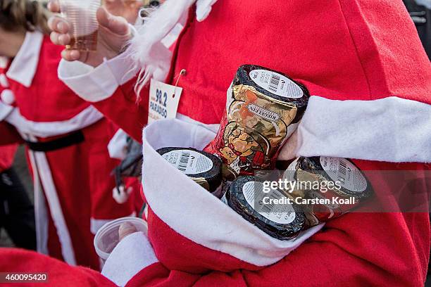 Man dressed as Santa Claus holds sweets in his hat as he attends the annual Santa Run on December 7, 2014 in Michendorf, Germany. At least 800 adults...