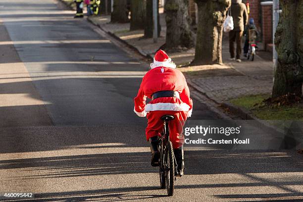 Man dressed as Santa Claus rides a bicycle as he and other participants dressed as Santa Claus attend the annual Santa Run on December 7, 2014 in...