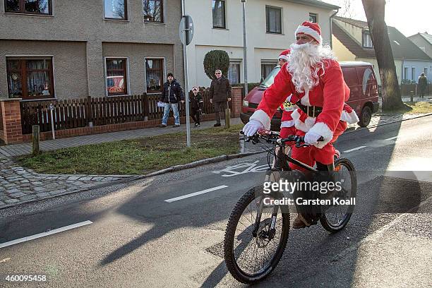 Man dressed as Santa Claus rides a bicycle as he and other participants dressed as Santa Claus attend the annual Santa Run on December 7, 2014 in...