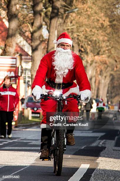 Man dressed as Santa Claus rides a bicycle as he and other participants dressed as Santa Claus attend the annual Santa Run on December 7, 2014 in...