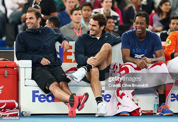 Roger Federer of the Indian Aces sits on the team bench with Pete Sampras and Gael Monfils during their teams match against the Singapore Slammers...