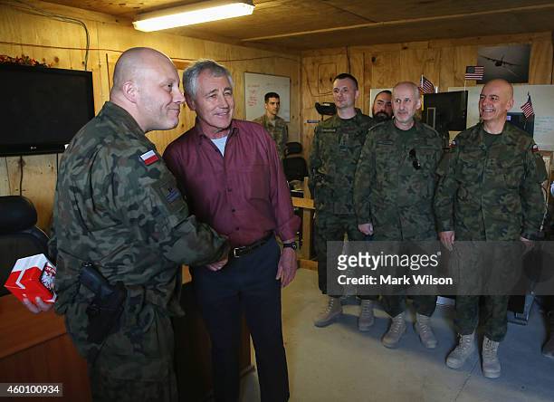 Secretary of Defense Chuck Hagel shakes hands with Ltc Adam Wloczewski during a visit with Polish troops, December 7, 2014 in FOB Gamberi,...