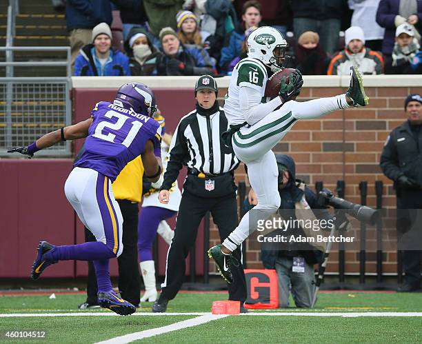Percy Harvin of the New York Jets pulls in a touchdown pass while Josh Robinson of the Minnesota Vikings applies pressure in the first quarter on...