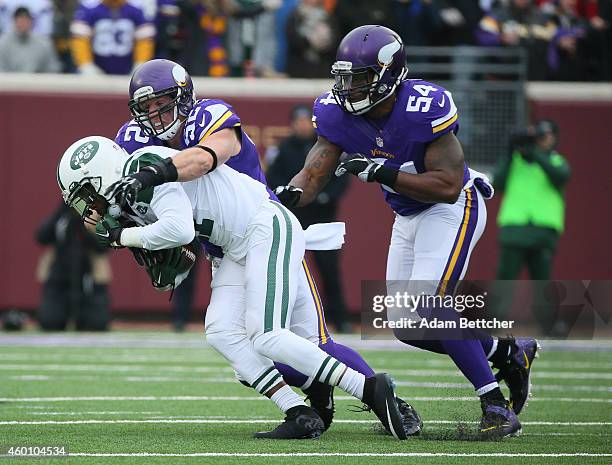 Geno Smith of the New York Jets recovers a fumble but gets sacked by Chad Greenway and Jasper Brinkley of the Minnesota Vikings in the first quarter...