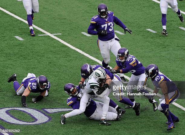 Corey Wootton and Chad Greenway of the Minnesota Vikings tackle Percy Harvin of the New York Jets during the first quarter of the game on December 7,...