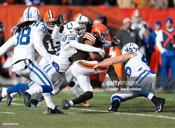 Travis Benjamin of the Cleveland Browns gets wrapped up by Colt Anderson and Matt Overton of the Indianapolis Colts during the second quarter at...