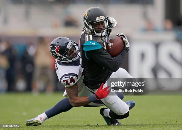 Marqise Lee of the Jacksonville Jaguars carries past A.J. Bouye of the Houston Texans during the first half of the game at EverBank Field on December...