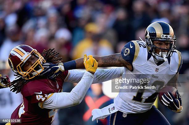 Strong safety Phillip Thomas of the Washington Redskins is stiff armed by wide receiver Stedman Bailey of the St. Louis Rams in the third quarter of...