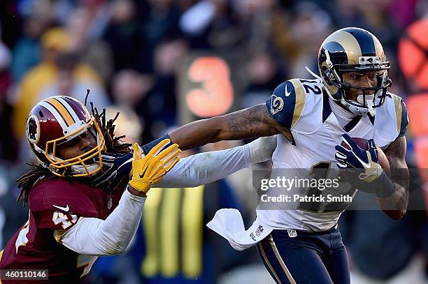 Strong safety Phillip Thomas of the Washington Redskins is stiff armed by wide receiver Stedman Bailey of the St. Louis Rams in the third quarter of...