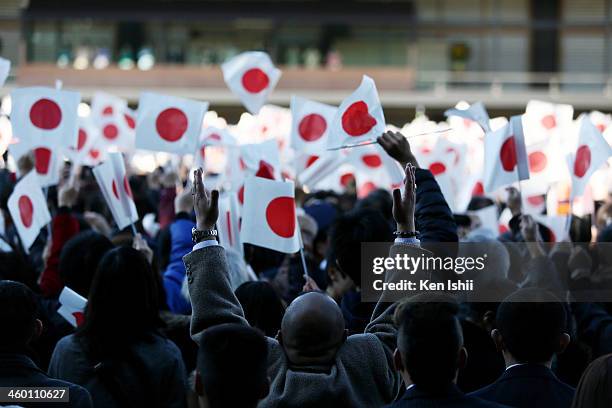 Well-wishers wave national flags and make banzai cheers during a celebration for the New Year by the Japanese Royal Family on the veranda of the...