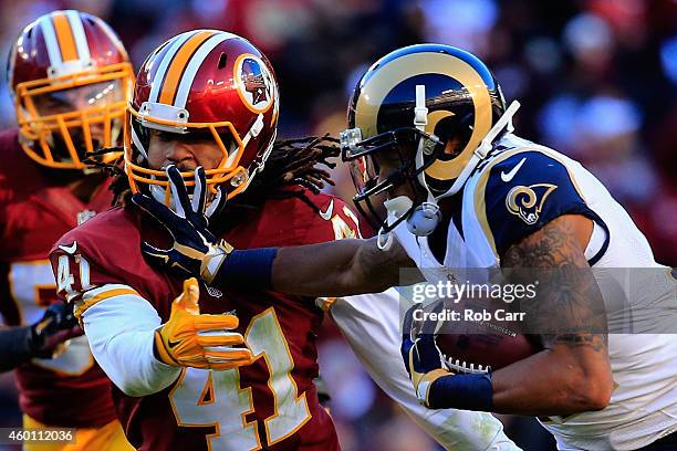 Wide receiver Stedman Bailey of the St. Louis Rams stiff arms safety Phillip Thomas of the Washington Redskins after catching a second half pass...