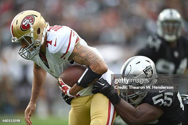 Colin Kaepernick of the San Francisco 49ers is sacked by Sio Moore of the Oakland Raiders in the first quarter at O.co Coliseum on December 7, 2014...