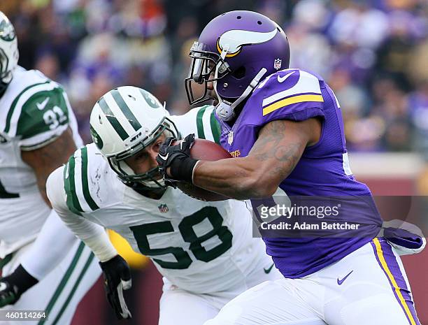Ben Tate of the Minnesota Vikings carries the ball while Jason Babin of the New York Jets eyes the play in the fourth quarter on December 7, 2014 at...