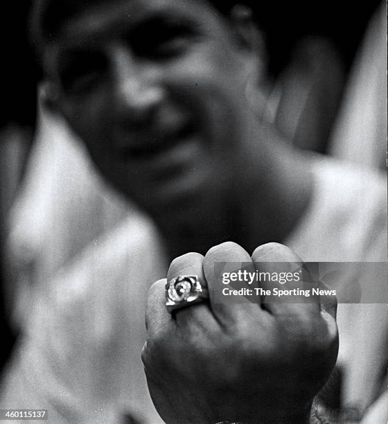 Stan Musial of the St. Louis Cardinals displays a ring he wears with the on it representing his jersey number in the locker room circa 1963.