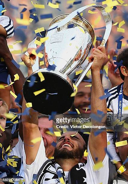 Landon Donovan of the Los Angeles Galaxy celebrates with the Philip F. Anschutz Trophy on the podium after the Galaxy defeated the New England...