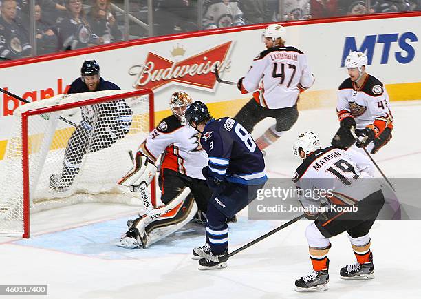 Goaltender Frederik Andersen of the Anaheim Ducks looks behind him as the puck shot by Jacob Trouba of the Winnipeg Jets rolls toward the net for a...