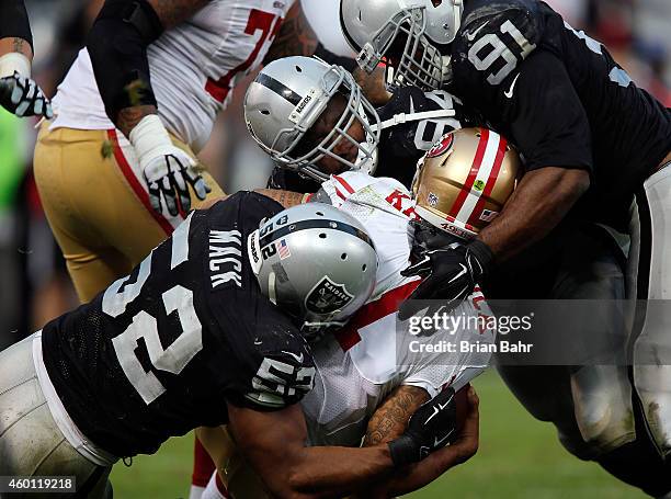 Justin Tuck of the Oakland Raiders, Antonio Smith of the Oakland Raiders, Khalil Mack of the Oakland Raiders sack Colin Kaepernick of the San...