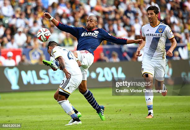 Teal Bunbury of the New England Revolution and A.J. DeLaGarza of the Los Angeles Galaxy vie for the ball in the second half during 2014 MLS Cup at...