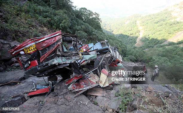 This picture taken on January 2, 2014 shows the remains of the local bus that slid off a mountain road killing at least 27 people at Malshej Ghat in...