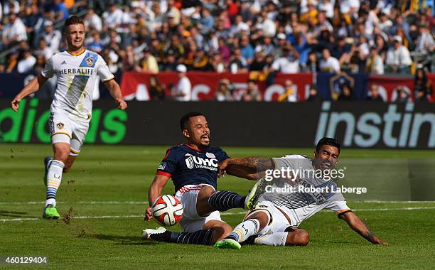 Charlie Davies of the New England Revolution gets tripped by A. J. DeLaGarza the Los Angeles Galaxy as Robbie Rogers looks on during the 2014 MLS Cup...