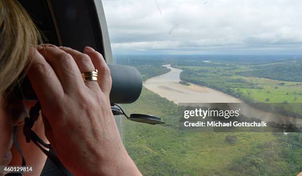 San Jose de Guaviare, Colombia A woman looks out of the window of a helicopter towards a cleard rain-forest on December 06, 2014 in National Park...