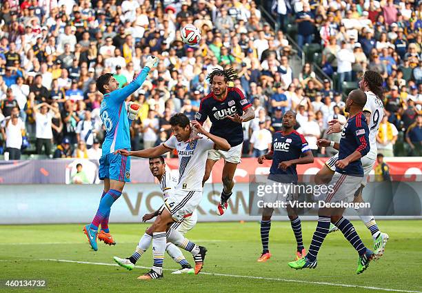 Goalkeeper Jaime Penedo of the Los Angeles Galaxy punches the ball away for a save Jermaine Jones of the New England Revolution goes over the top of...