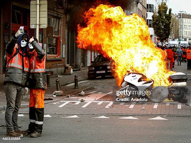 Protestors take a selfie in front of burning police motorbike in Brussels, on November 6, 2014. Belgians protest government's policies that will...