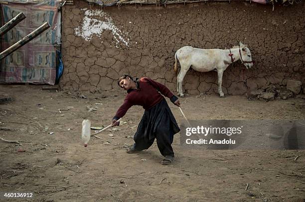 An Afghan refugee boy plays with a plastic bottle in Islamabad, Pakistan, on Universal Children's Day signed in 1989 by the United Nations and other...