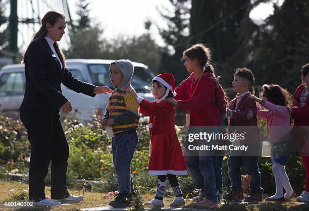 Displaced Iraqi Christian children, who were forced to flee their homes as the Islamic State advanced earlier this year, arrive for an afternoon of...