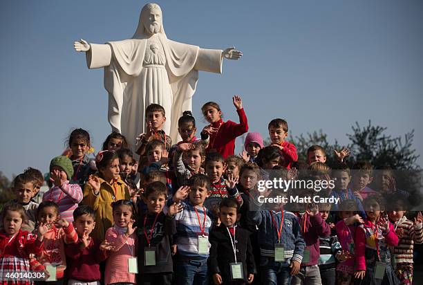 Displaced Iraqi Christian children, who were forced to flee their homes as the Islamic State advanced earlier this year, gather for a photograph as...