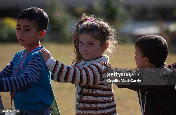 Displaced Iraqi Christian children, who were forced to flee their homes as the Islamic State advanced earlier this year, arrive for an afternoon of...