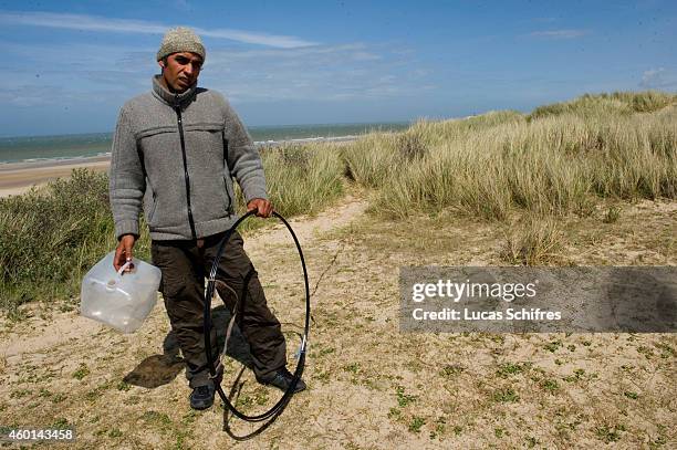 Afghan migrant Asif Hussainkhil shows where he is hiding the empty milk bottles and other bits he made a raft from during his desperate attempt to...