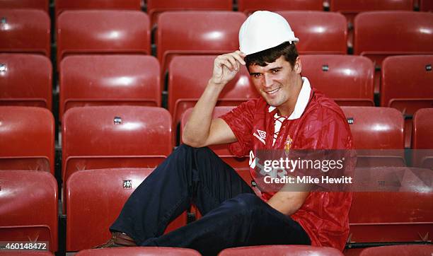 New Manchester United signing Roy Keane poses with a builders hard hat at Old Trafford after signing from Nottingham Forest ahead of the 1993/94...