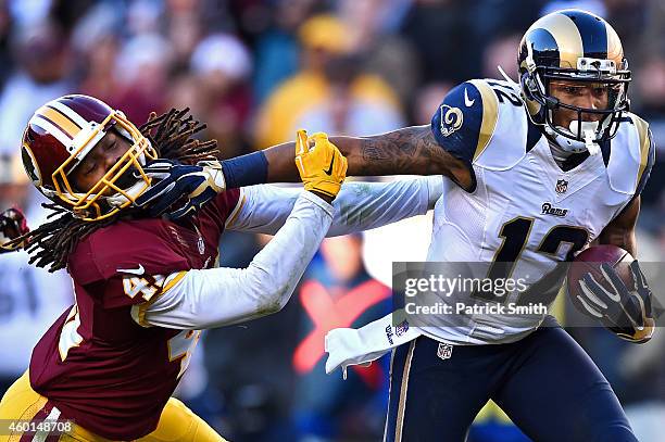 Strong safety Phillip Thomas of the Washington Redskins is stiff armed by wide receiver Stedman Bailey of the St. Louis Rams in the third quarter of...