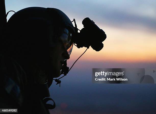 Crew member looks out the window of a UH-60 Blackhawk helicopter from Bravo Co 2/147th AVN Renegades flying support for U.S. Secretary of Defense...