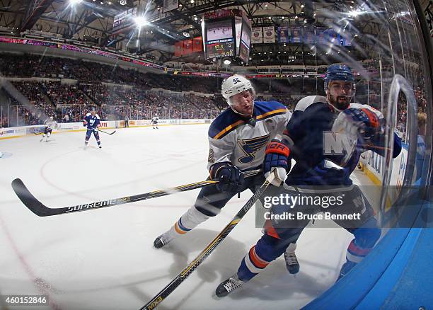 Nick Leddy of the New York Islanders is hit by David Backes of the St. Louis Blues at the Nassau Veterans Memorial Coliseum on December 6, 2014 in...