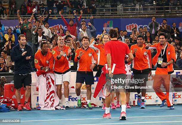 Roger Federer of the Indian Aces is congratulated by his team mates after breaking the serve of Novak Djokovic of the UAE Royals in his match during...