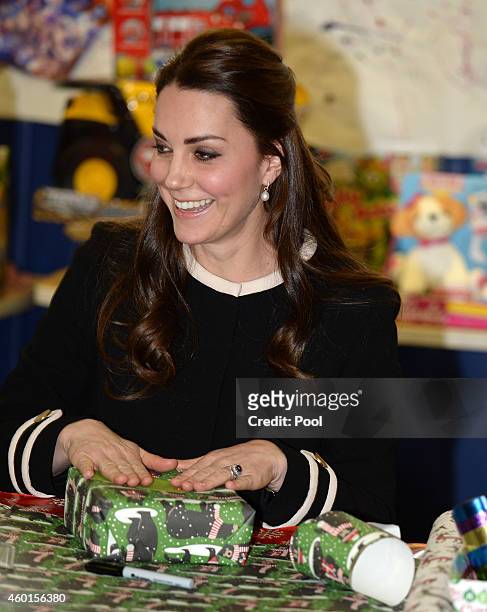 Catherine, Duchess of Cambridge, helps to wrap Christmas presents during a visit with Chirlane McCray, the first lady of New York, to the Northside...