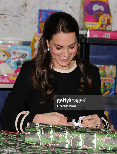 Catherine, Duchess of Cambridge, helps to wrap Christmas presents during a visit with Chirlane McCray, the first lady of New York, to the Northside...