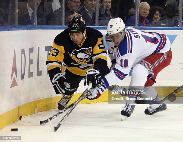 Steve Downie of the Pittsburgh Penguins is tripped up by Marc Staal of the New York Rangers during the first period at Madison Square Garden on...