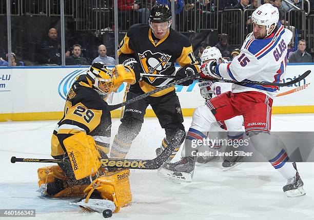 Marc-Andre Fleury of the Pittsburgh Penguins makes a save as Tanner Glass of the New York Rangers and Christian Ehrhoff of the Pittsburgh Penguins...