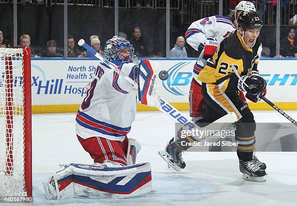 Henrik Lundqvist of the New York Rangers makes a blocker save as Steve Downie of the Pittsburgh Penguins crashes the net at Madison Square Garden on...