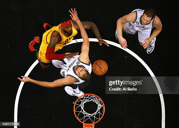 LeBron James of the Cleveland Cavaliers battles Jerome Jordan, and Bojan Bogdanovic of the Brooklyn Nets during their game at the Barclays Center on...