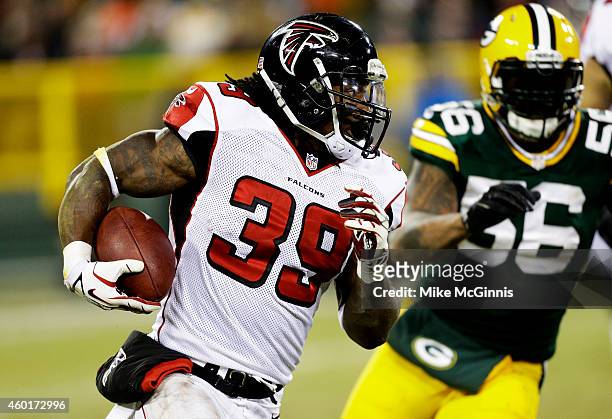 Steven Jackson of the Atlanta Falcons carries the ball against Julius Peppers of the Green Bay Packers in the second quarter at Lambeau Field on...